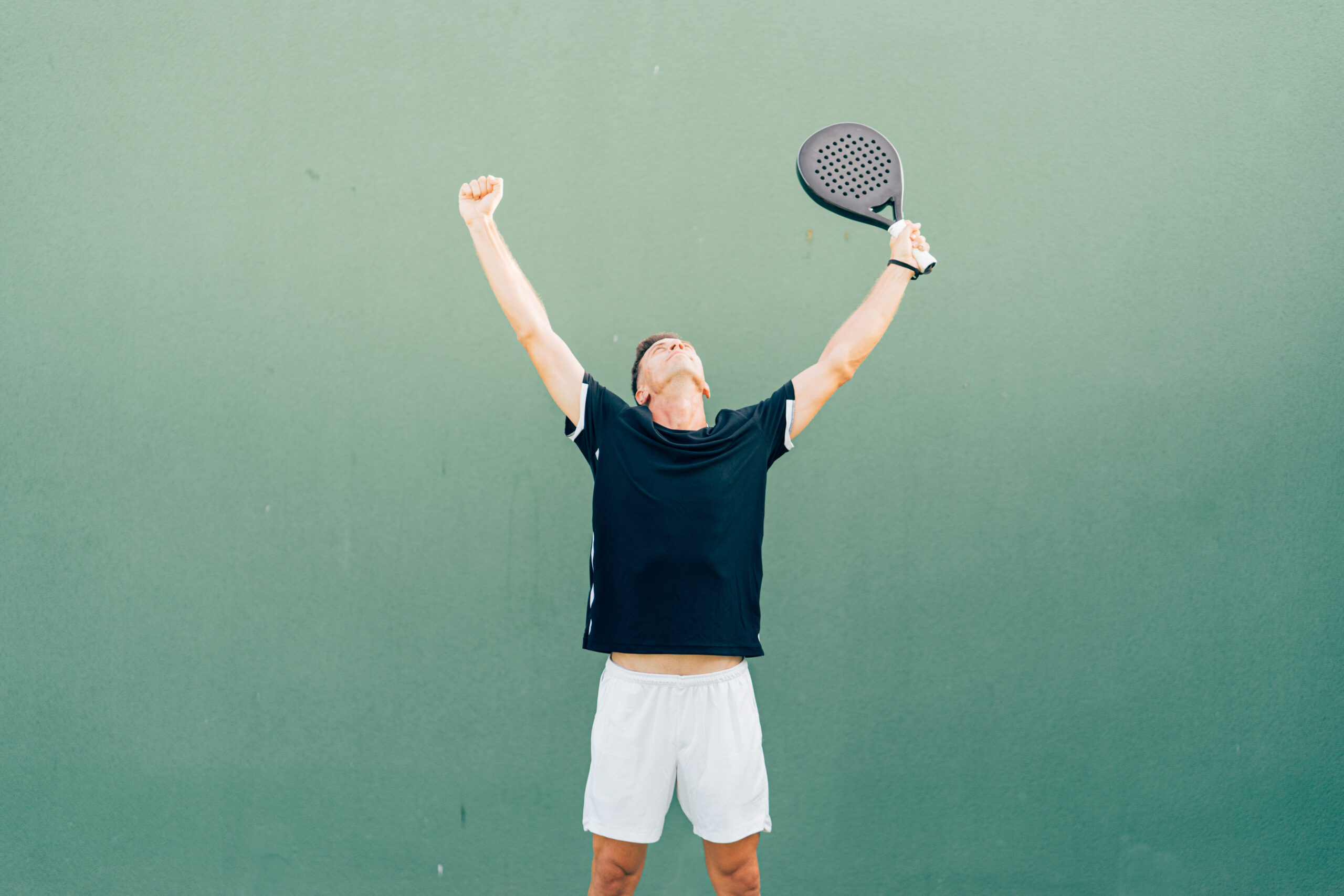 Paddle tennis player celebrating victory at the end of the match